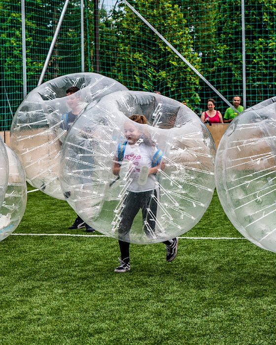 Smiling child running inside a bubble during a kids' game